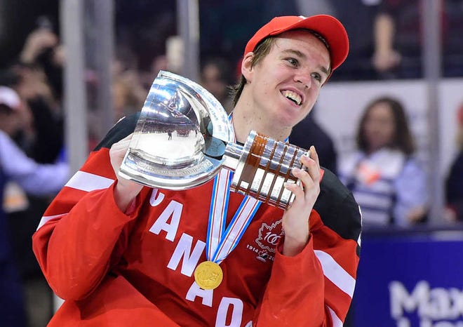 FILE - In this Jan. 5, 2015, file photo, Canada's Connor McDavid skates with the trophy following his team's 5-4 win over Russia in the title game at the hockey World Junior Championship in Toronto. The Edmonton Oilers have won the NHL draft lottery and the right to select McDavid first overall. (Frank Gunn/The Canadian Press via AP, File) MANDATORY CREDIT