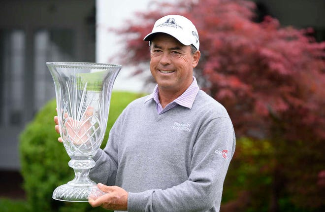 PGA Champions Tour player Olin Browne holds the winner's trophy after rain forced the cancellation of the final round of the Greater Gwinnett Championship golf tournament Sunday, April 19, 2015, in Duluth, Ga. Browne won the shortened event at 12 under after 36 holes. (AP Photo/David Tulis)
