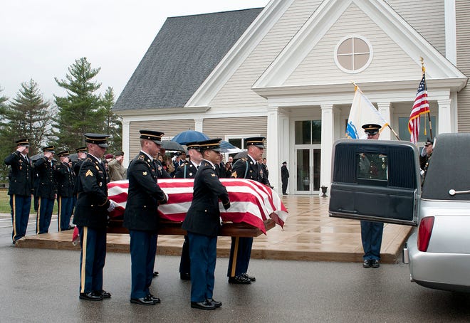 Fellow soldiers carry the casket of Cpl. John M. Dawson this morning.