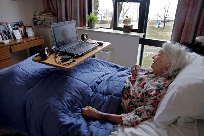 Patient Louise Irving watches a laptop computer with her daughter's morning wake-up video playing at The Hebrew Home of Riverdale, in New York. THE ASSOCIATED PRESS