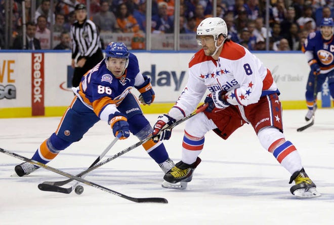 New York Islanders' Nikolay Kulemin, left, tries to get the puck away from Washington Capitals' Alex Ovechkin during the first period of Game 3 of a first-round NHL hockey playoff series Sunday, April 19, 2015, in Uniondale, N.Y. (AP Photo/Seth Wenig)