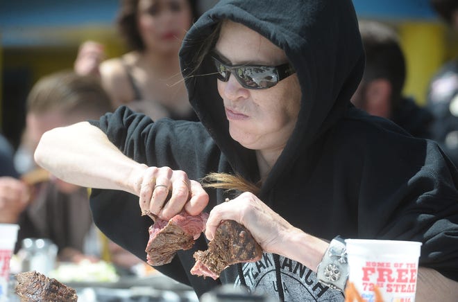 Molly Schuyler tears apart pieces of a 72-ounce steak on Sunday. Sean Steffen/The Amarillo Globe News via The Associated Press