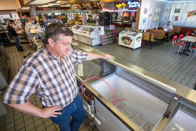 Brett Smith, owner of Scoops Ice Cream, looks over the empty ice cream case in Brenham, Texas. In compliance with the Blue Bell Ice Cream recall, Smith pulled all ice cream from his freezers.