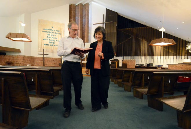 Inside the First United Methodist Church of Moorestown's sanctuary, the Rev. Richard W. Nichols consults with Associate Pastor HeyYoung Horton.