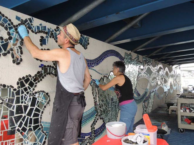 Tiffanie.Reynolds@jacksonville.com Artist Kate Rouh and husband Kenny Rouh continue their work on the St. Johns River mirror mosaic. The couple started the project last month and hope to have it complete in May.