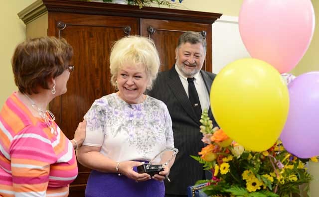 Denelle Lane Robertson, center, is surprised with the Administrative Professional of the Year Award by Laura Lee Sylvester, president of the Kinston-Lenoir County Chamber of Commerce, while her husband, K.R. Robertson, looks on Tuesday at Perry, Perry and Perry attorneys.