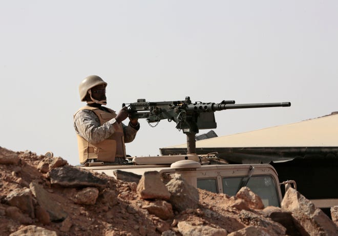 A Saudi soldier sits on top of an armor vehicle as he aims his weapons, on the border with Yemen, at a military point in Najran, Saudi Arabia, Tuesday.