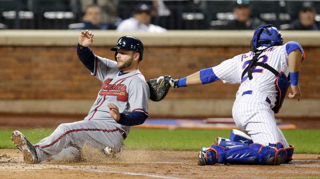 Atlanta's A.J. Pierzynski beats the tag of New York catcher Kevin Plawecki in the second inning, scoring on Andrelton Simmons' single to center field. New York manager Terry Collins unsuccessfully challenged the play,