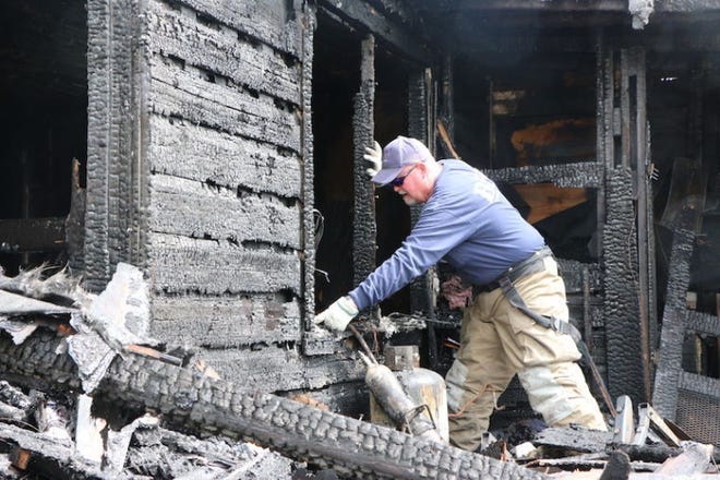 Brownwood Fire Marshal Buddy Preston looks through the charred remains Wednesday morning of a carport that burned, along with the home the carport is attached to, at 1508 Waco in Brownwood. Preston was standing in the area where he said the fire started shortly bef