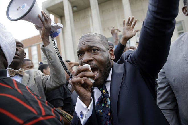 The Rev. Jamal Bryant leads a rally outside the Baltimore Police Department's western-district station for Freddie Gray. Gray's mother was overcome with grief during Tuesday's protest.