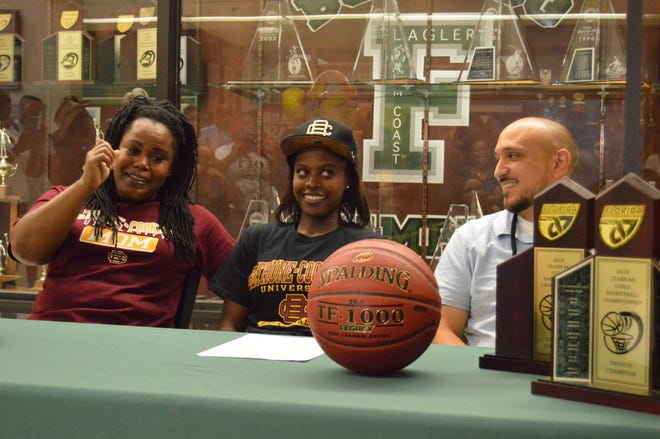 Flagler Palm Coast’s Armani Walker is joined by her mother, Courtney Ousley, left, and coach Javier Bevacqua, right, as she signs to play with Bethune-Cookman on Wednesday.