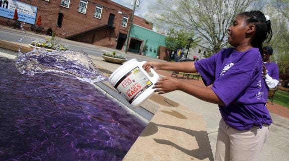 Brittany Randolph/The Star
Brain tumor survivor Walasia Vinson helps turn the Raper-Roark Plaza fountain in Shelby purple on Tuesday. Relay for Life teams will gather to raise money at "Paint Cleveland County Purple" on Wednesday in uptown Shelby.