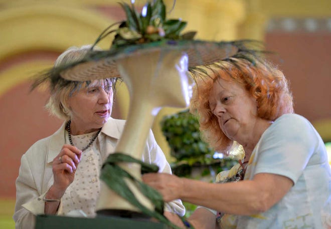 Mary Byrd and Jan Colvin create a hat with vegetation and feathers for a contest as part of the Sacred Heart Garden Festival on Thursday afternoon. The three-day event begins today at 9 a.m., with speakers at 9:30 a.m.