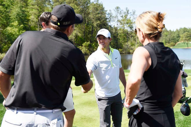 McIlroy (center) shakes hands with Randy Peitsch. McIlroy, a surprise guest on Friday, gave a clinic and later did a Q&A with the 54 players.