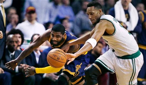 Cleveland guard Kyrie Irving, left, and Boston guard Evan Turner scramble for a loose ball during NBA playoff action Thursday. AP PHOTO