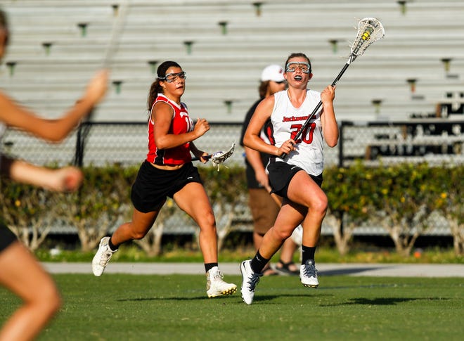 Jacksonville's Allison Ingraham (20) races down the field with the ball as New Bern's Shannon Lloyd chases during the second half of the Cardinals' 13-7 Conference II victory over the Bears.
