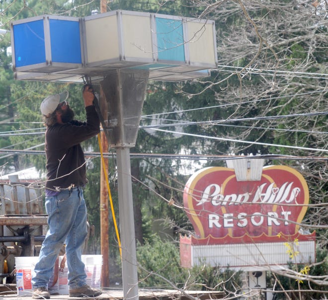 Nate Berry of Sterling Builders unbolts the Westinghouse lamps from atop its pole at the former Penn Hills property in Analomink on Tuesday, April 21, 2015. The lights were brought from the 1964 New York World's Fair and lit the grounds at Penn Hills until its closure. The lights are to be restored after they are taken down from their poles. (Keith R. Stevenson/Pocono Record)