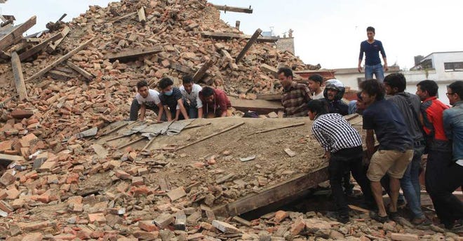 In this April 25, 2015 photo, people try to lift the debris from a temple at Hanumandhoka Durbar Square after an earthquake in Kathmandu, capital of Nepal, Saturday, April 25, 2015. A strong earthquake shook Nepal's capital and the densely populated Kathmandu Valley before noon Saturday, causing extensive damage with toppled walls and collapsed buildings, officials said. (Sunil Sharma/Xinhua via AP) NO SALES