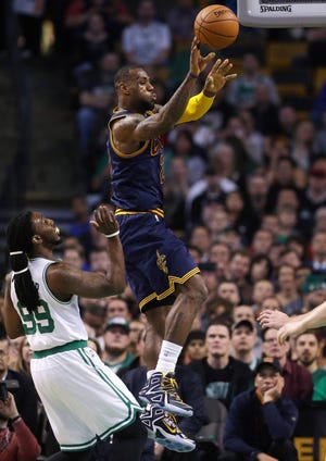 Cavaliers forward LeBron James passes as Celtics forward Jae Crowder looks on in the first quarter of a first-round NBA playoff basketball game in Boston on Sunday.