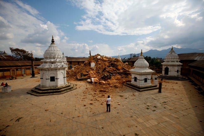 People look at the debris of one of the oldest temples after it was damaged in Saturdayís earthquake, in Kathmandu, Nepal, Sunday, April 26, 2015. The earthquake centered outside Kathmandu, the capital, was the worst to hit the South Asian nation in over 80 years. It destroyed swaths of the oldest neighborhoods of Kathmandu, and was strong enough to be felt all across parts of India, Bangladesh, China's region of Tibet and Pakistan.(AP Photo/Niranjan Shrestha)