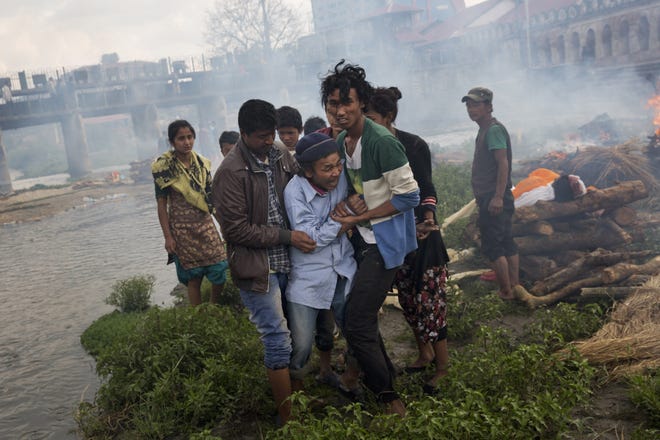 A Hindu man breaks down during a funeral of Saturdayís earthquake victims on the Pashupatinath bank of Bagmati river, in Kathmandu, Nepal, Sunday, April 26, 2015. The earthquake centered outside Kathmandu, the capital, was the worst to hit the South Asian nation in over 80 years. It destroyed swaths of the oldest neighborhoods of Kathmandu, and was strong enough to be felt all across parts of India, Bangladesh, China's region of Tibet and Pakistan.(AP Photo/Bernat Armangue)