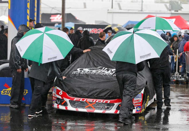 The crew for Trevor Bayne (6) pushes his car to the inspection station as rain falls at Richmond International Raceway in Richmond, Va., Saturday, April 25, 2015. The NASCAR Sprint Cup series races was postponed until Sunday. (AP Photo/Steve Helber)