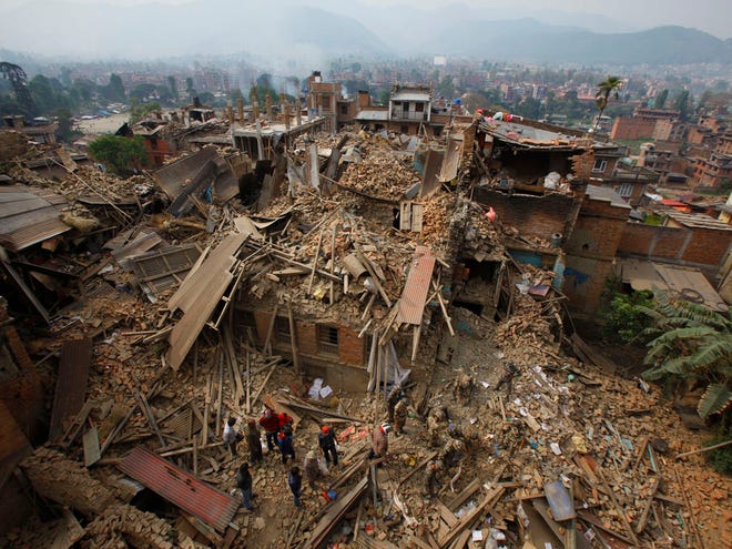 Rescue workers remove debris as they search for victims of earthquake in Bhaktapur near Kathmandu, Nepal, Sunday, April 26, 2015. A strong magnitude earthquake shook Nepal's capital and the densely populated Kathmandu Valley before noon Saturday, causing extensive damage with toppled walls and collapsed buildings, officials said.