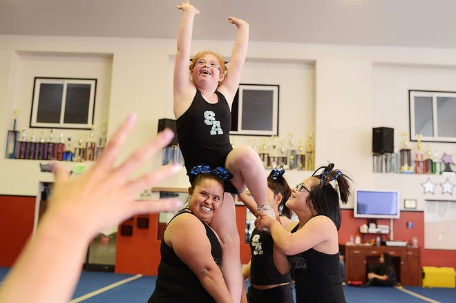 Wyatt Jane Price, 13, center, is held up during a cheer practice routine while head coach Breona Thompson waves her hand in instruction Wednesday at High Desert Cheer-Spirit Athletics in Hesperia, April 22, 2015. Wyatt along with Karina Lerma, 9, Cynthia Orozco, 24, and Itzel Gonzalez, 14, of Team Stardom, an Apple Valley based special need cheer squad, will be among the first squads to compete at the Special Olympics World Games this summer in Los Angeles. (Jose Huerta, Daily Press)