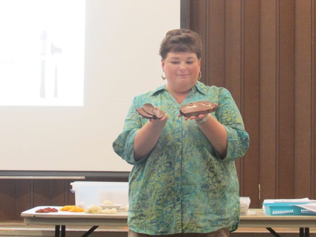Jeannie Leonard shows attendees at the Lunch and Learn on April 17 how portions of different food have changed over the course of 20 years.