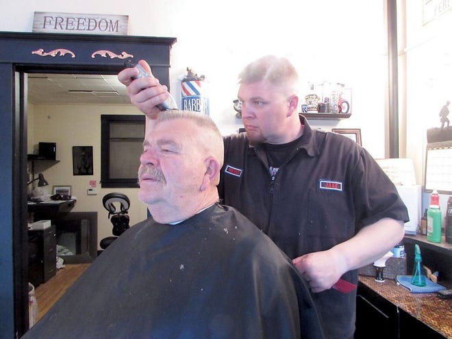 Jake’s Place owner Jake Ista gives a haircut to his father, Steve Ista. Ista relocated his barber shop from North Pekin to the 200 block of Court Street in Pekin after 353 Court LLC developers Todd Thompson and Steve Foster stabilized the former L.R. Boarding House that was built in 1877.