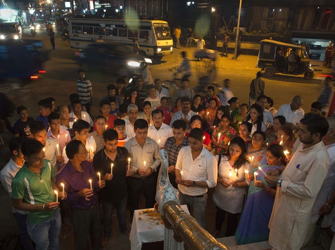 Nepalese people living in India’s northeastern Assam state light candles and offer prayers for victims of Saturday’s earthquake in Gauhati, India, Monday.
