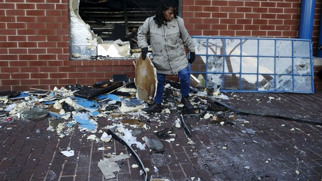 A woman cleans up a CVS store that was looted and set on fire during clashes with police on Monday in Baltimore, Maryland April 28, 2015. (REUTERS/Shannon Stapleton)