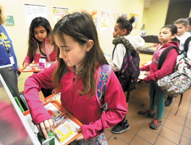 Alexis Morris, 10, a fourth-grader at Cedar Elementary, selects a milk for breakfast at the school’s cafeteria. This school year, Canton City Schools began offering free breakfast and lunch to all of its students through a federal program called Community Eligibility Provision.