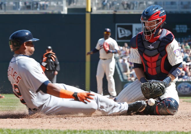 Minnesota Twins catcher Chris Herrmann, left, loses the ball as Detroit Tigersí Yoenis Cespedes scores the go-ahead run in the eighth inning of a baseball game, Wednesday, April 29, 2015, in Minneapolis. The Tigers won 10-7. (AP Photo/Jim Mone)