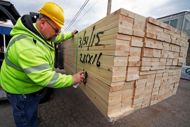In this March 31, 2015 photo, Roy Livesey marks a pallet of 2x4's at the Allegheny Millwork and Lumberyard in Pittsburgh. The Commerce Department releases first-quarter gross domestic product on Wednesday, April 29, 2015. (AP Photo/Gene J. Puskar)