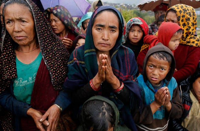 A female villager named Ramaya clasps her hands as she pleads for food after an aid relief helicopter lands at the remote mountain village of Gumda, near the epicenter of Saturday's massive earthquake in the Gorkha District of Nepal, Wednesday, April 29, 2015. (AP Photo/Wally Santana)
