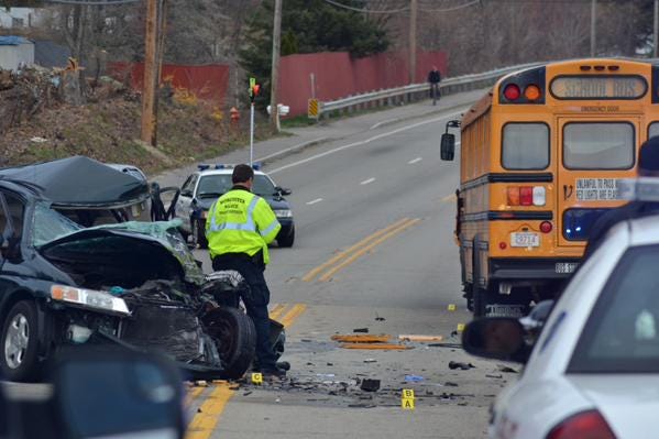 Worcester police investigate at the site where a minivan and a school bus collided on Route 20 Wednesday. A woman was seriously injured.