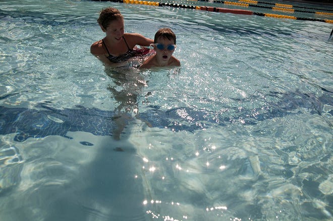 Levi Katzenberger, 6, learns swim strokes and technique from lifeguard Savannah Johnson, 15, at Twin Lions Outdoor Pool, June 28, 2012. Gonzalez was one of 34 youth who took part in the Family and Morale, Welfare and Recreation swim camp, which was open to youth ages 5 to 8, and taught water safety and first aid skills.