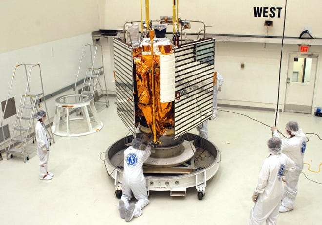 In this undated photo provided by NASA, technicians with The Johns Hopkins University Applied Physics Laboratory in Titusville, Fla., prepare the MESSESNGER spacecraft for a move to a hazardous processing facility in preparation for loading the spacecraft's hypergolic propellants. (NASA via AP)