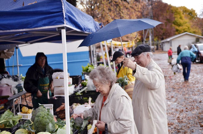 Rain doesn't keep fans of fresh vegetables from Beaver County farmers markets. Visitors to the Ambridge Farmers Market last fall browse the fresh produce at Enon Country Gardens' stand.