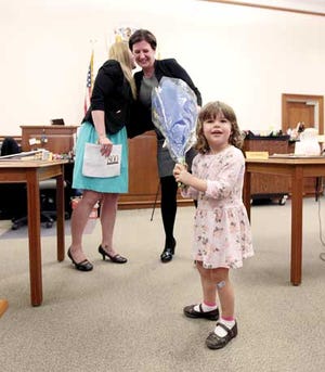 Photo by Daniel Freel/New Jersey Herald Margaux Yaskovic, 3, daughter of Kate Yaskovic, right, holds her mother’s flowers as she is honored with the 2015 Project Self-Sufficiency Award by Kyersten Rozanski, of PSS, during Law Day.