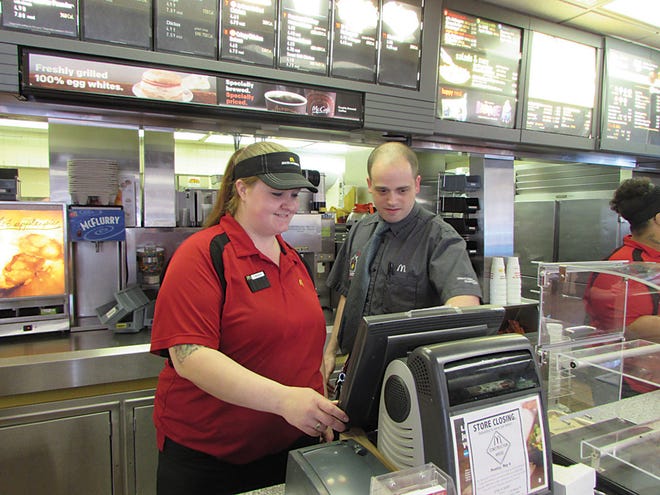 Lower Court Street McDonald’s restaurant Manager Brad Clutter demonstrates the use of the cash register to Crew Member Amanda Brown during a shift Friday. The store, located at 1013 Court St., will close at 9 p.m. Sunday and will be demolished. A new store will be built.