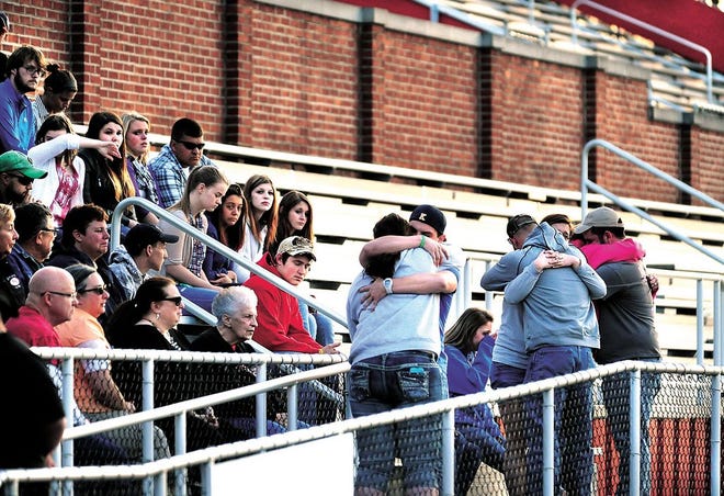 Friends and family of Neil Wise, who died after a traffic crash Friday morning, comfort each other during a vigil Friday night in Woody Hayes Quaker Stadium, where Wise played football before graduating from New Philadelphia High School.