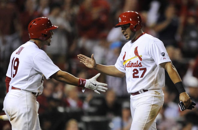 Cardinals' Jhonny Perlata (27) is congratulated by Jon Jay (19) after scoring on a single by Mark Reynolds against the Pirates in the seventh inning on Friday in St. Louis.