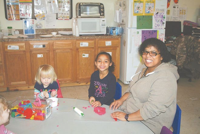 Wyneen Medina, Head Start teacher, sits with Madison Summers and Kayleigh Coplin at an activity table. The children are being prepared for kindergarten through literacy, math and science skills and social emotional experiences.