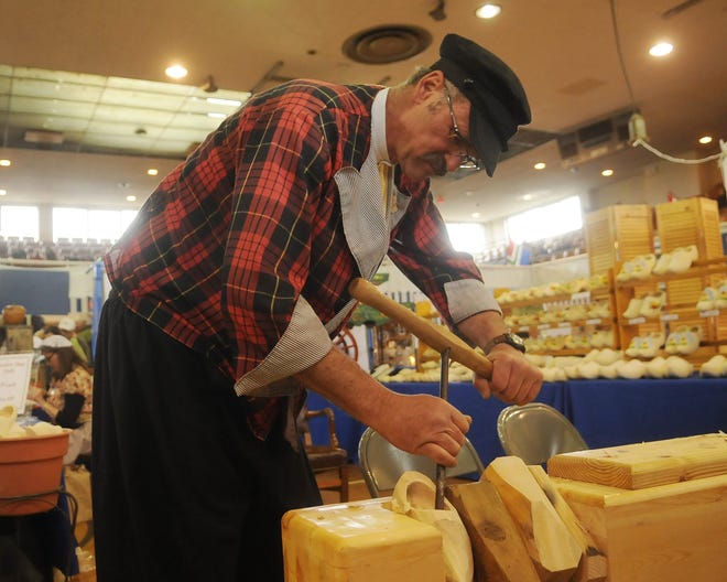 Rick Klompmaker carves out a pair of wooden shoes during the Marktplaats at the Holland Civic Center. 

Sentinel file