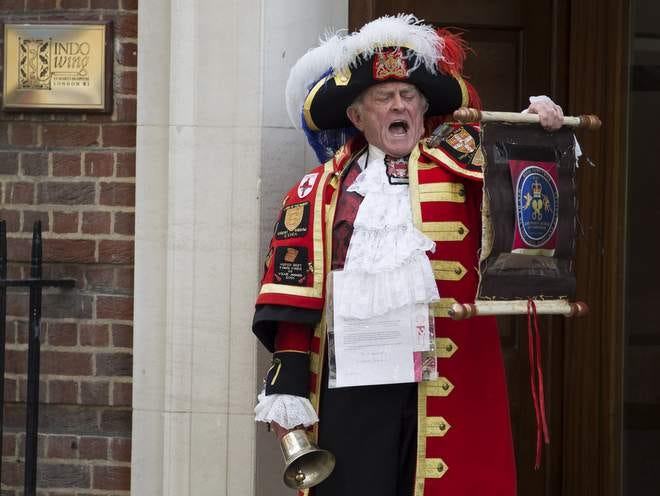 Tony Appleton, a town crier, announces the birth of the royal baby outside the Lindo Wing, St. Mary's Hospital, London, Saturday, May 2, 2015. Kate, the Duchess of Cambridge, has given birth to a baby girl, royal officials said Saturday. (Daniel Leal-Olivas/PA via AP)