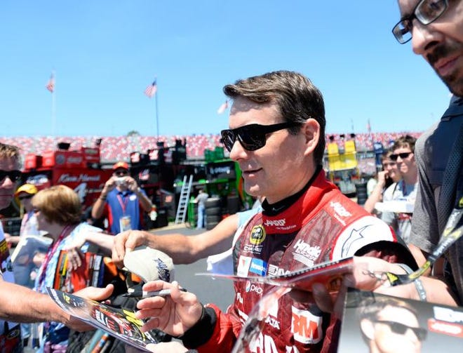 Pole winner Jeff Gordon signs autographs in the garage area during qualifying for Sunday's NASCAR Sprint Cup Series auto race at Talladega Superspeedway, Saturday, May 2, 2015, in Talladega, Ala.