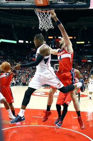 Atlanta Hawks forward Paul Millsap, front, passes as Washington Wizards center Marcin Gortat, right, defends in the first half of an NBA second-round basketball payoff series game Sunday, May 3, 2015, in Atlanta. (AP Photo/John Bazemore)