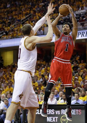 Chicago's Derrick Rose, right, shoots over Cleveland defender Timofey Mozgov during the first half Monday in Cleveland.